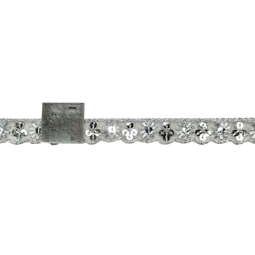 Decorative ribbon with floral patterns and a ruler for scale on a white background